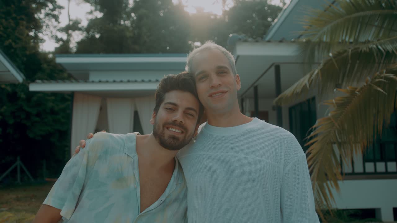 Two men in a loving embrace at tropical house