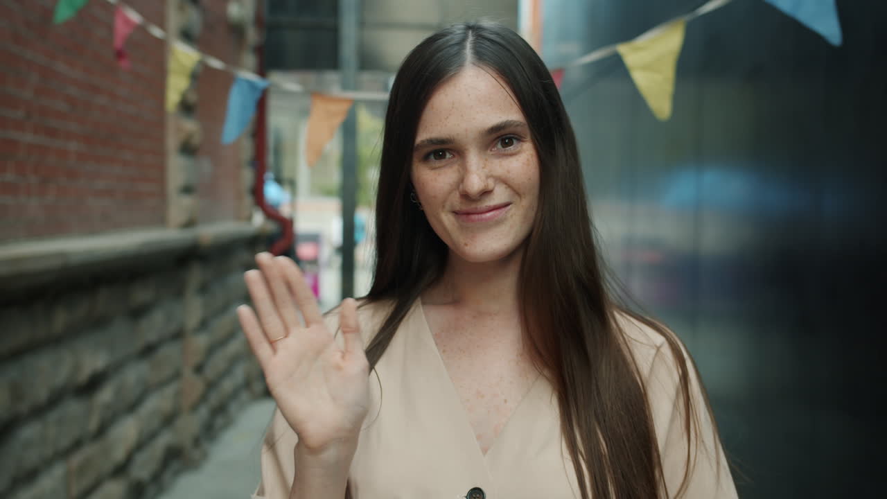 Woman Smiling and Waving in an Alley