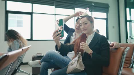 young couple taking pictures together with their phones in the lobby.