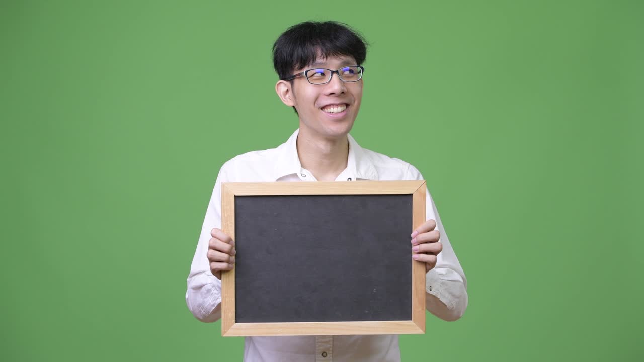 생각 하는 동안 검은판 을 들고 있는 젊은 아시아인 사업가