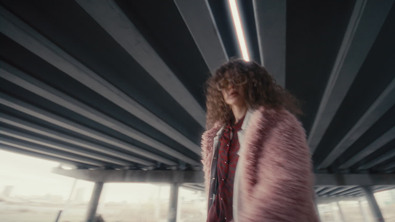 Cool Girl in Trendy Outfit Dancing and Posing on Camera under Urban Overpass