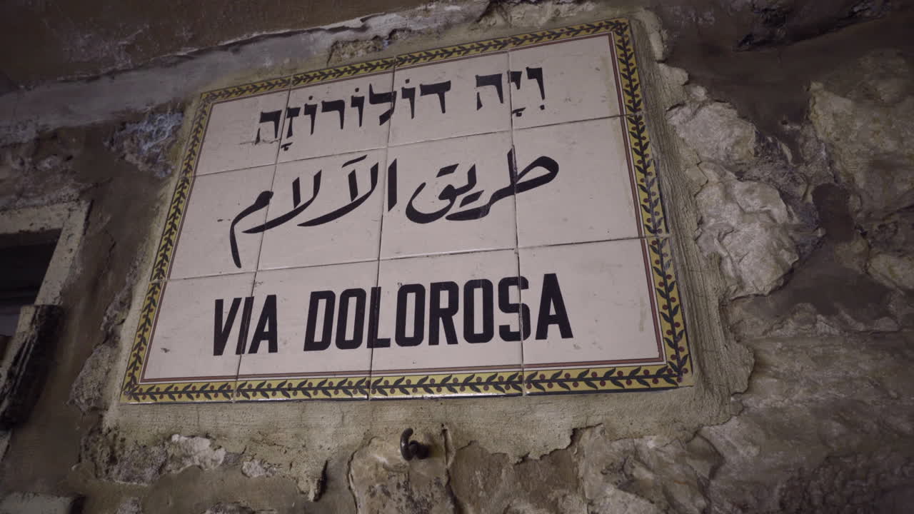 Close up pivoting view of the Via Dolorosa sign, marking the route where Jesus Christ carried the cross in Jerusalem, Israel.