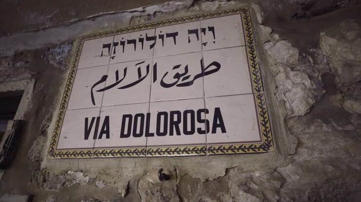 Primo piano con vista girevole del cartello Via Dolorosa, che segna il percorso dove Gesù Cristo portò la croce a Gerusalemme, Israele