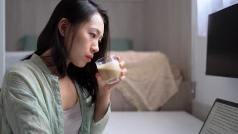 asian writer with laptop and coffee at home