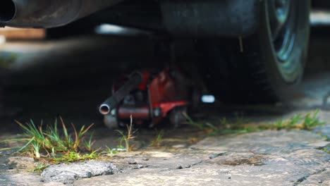 Slow-motion---A-man-put-a-jack-under-the-car-for-the-process-of-changing-tires