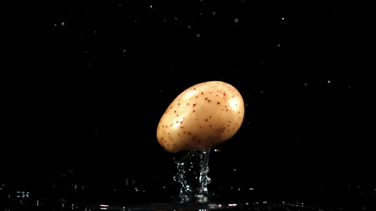 Rallentatore di una patata che cade nell'acqua con schizzi