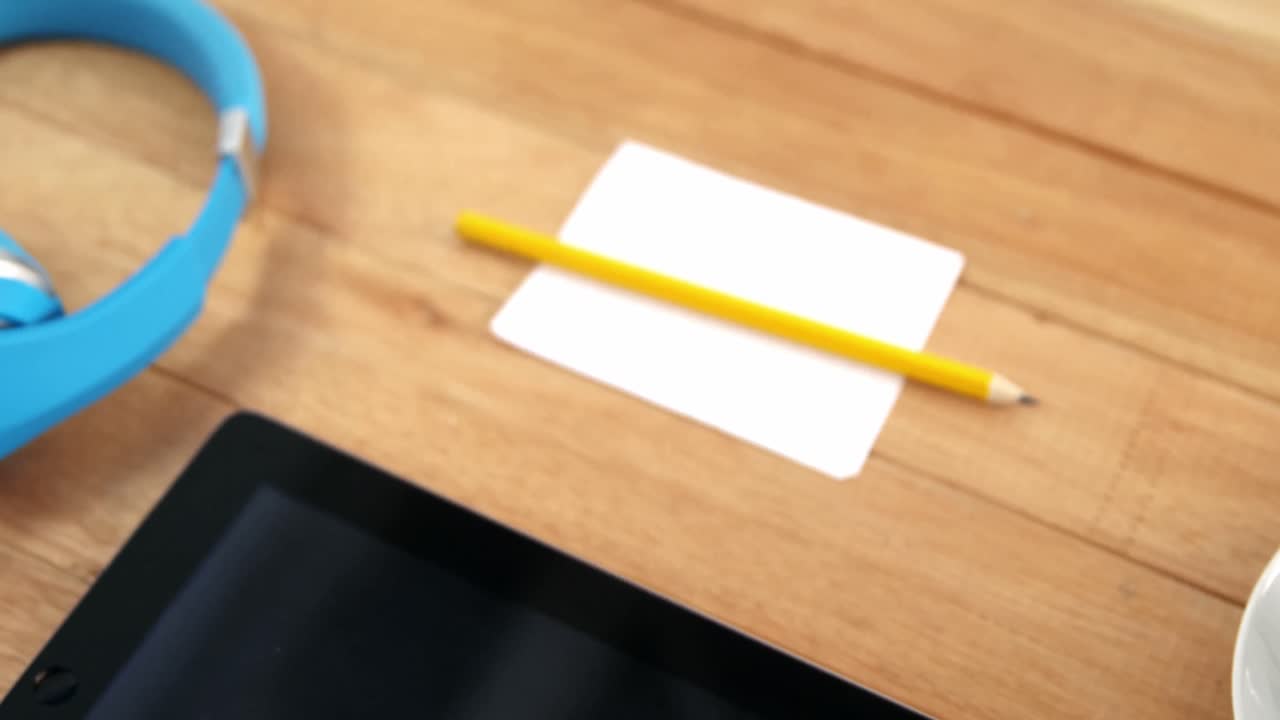 taza de café con tableta digital, auriculares, bolígrafo y papel