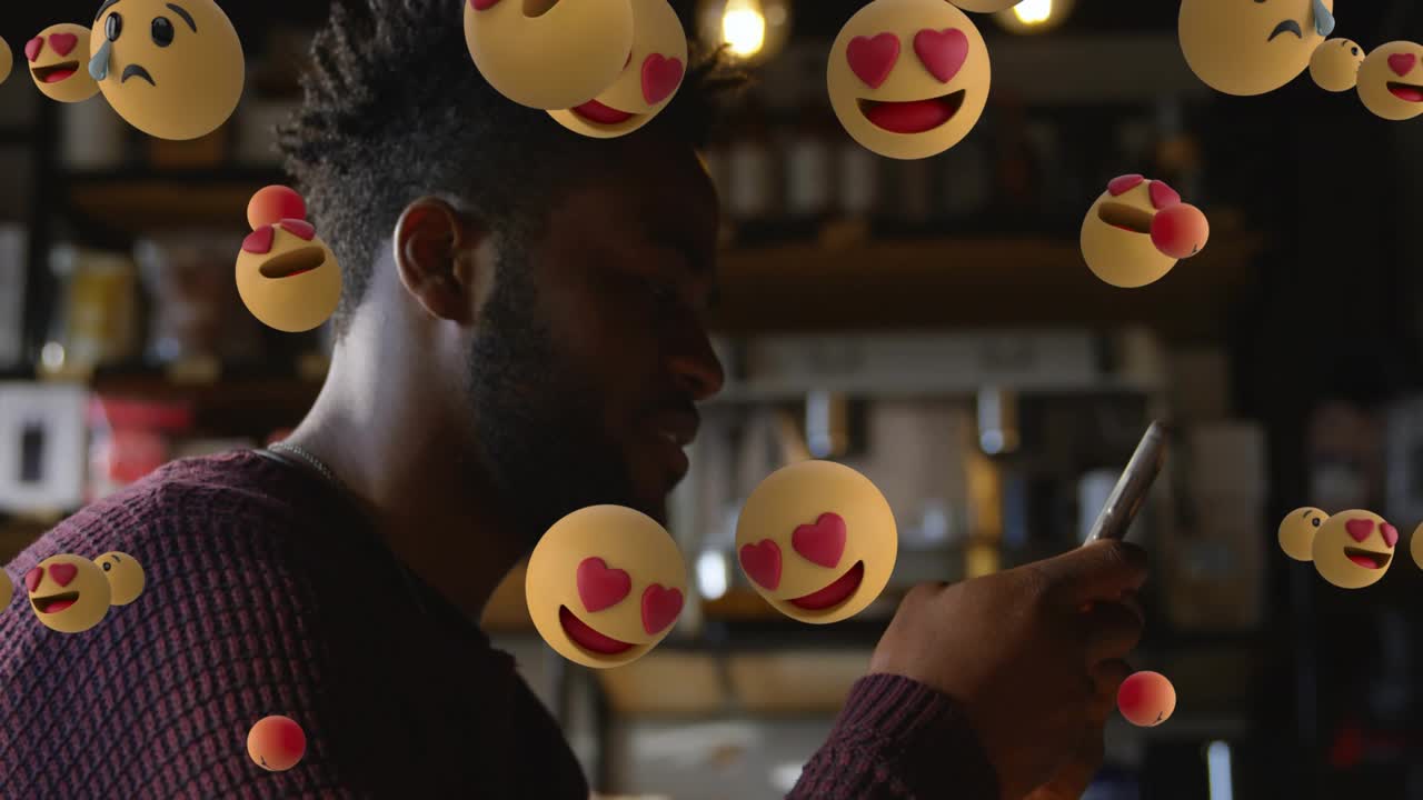 Man scrolling tapping smartphone in cafe, social media emoji cloud emerging dispersing smiling