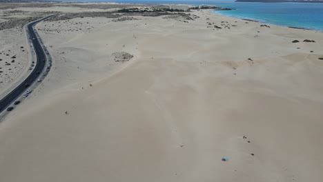 vista aérea por encima de la carretera a través de las dunas de arena en la playa de corralejo en fuerteventura, islas canarias, españa