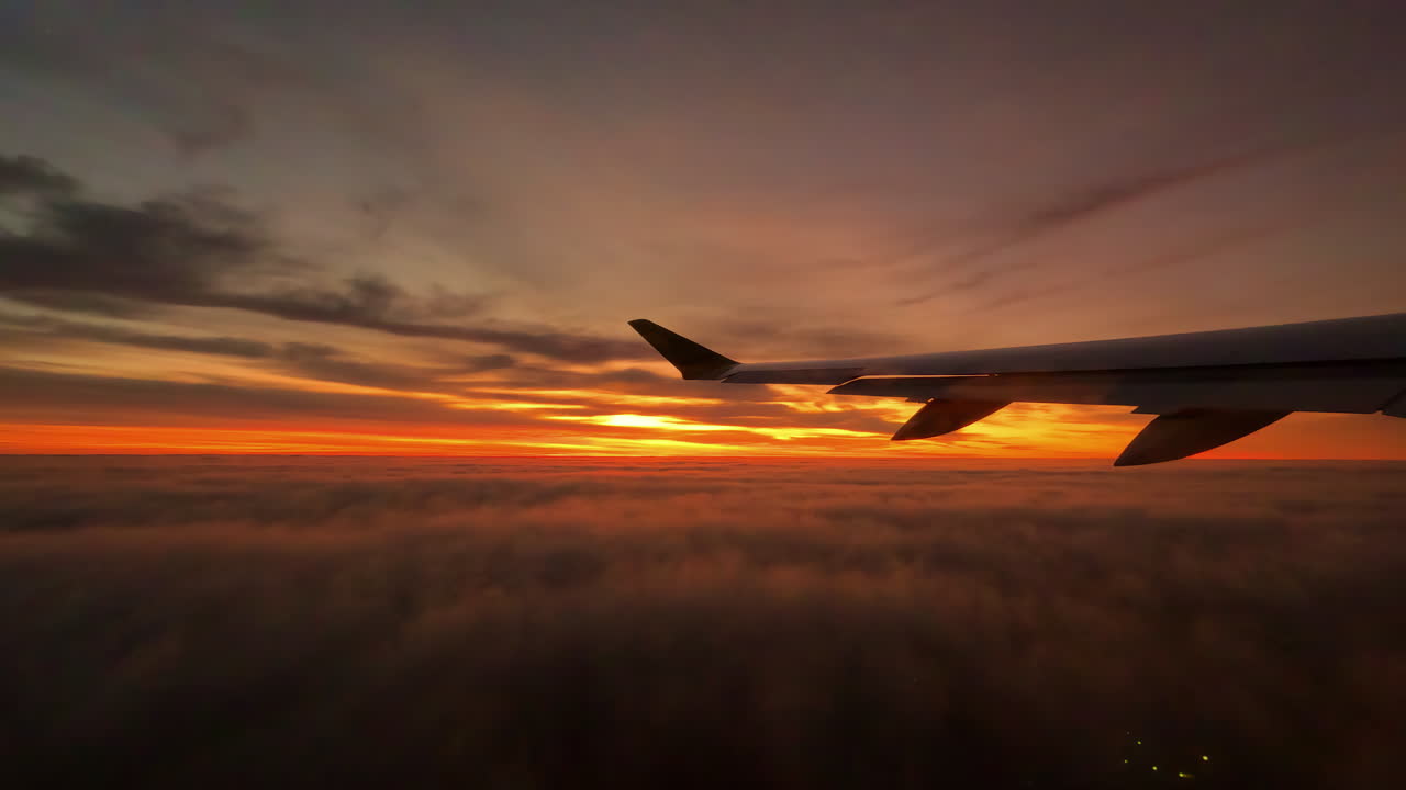 On a commercial flight looking out the airplane window at a stunning sunset or sunrise