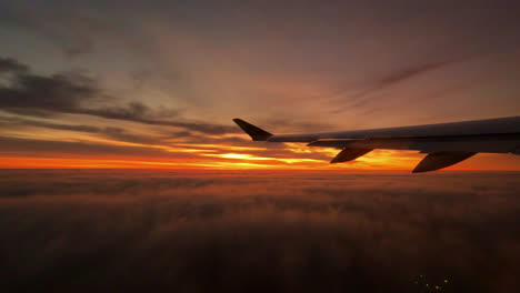 On-a-commercial-flight-looking-out-the-airplane-window-at-a-stunning-sunset-or-sunrise