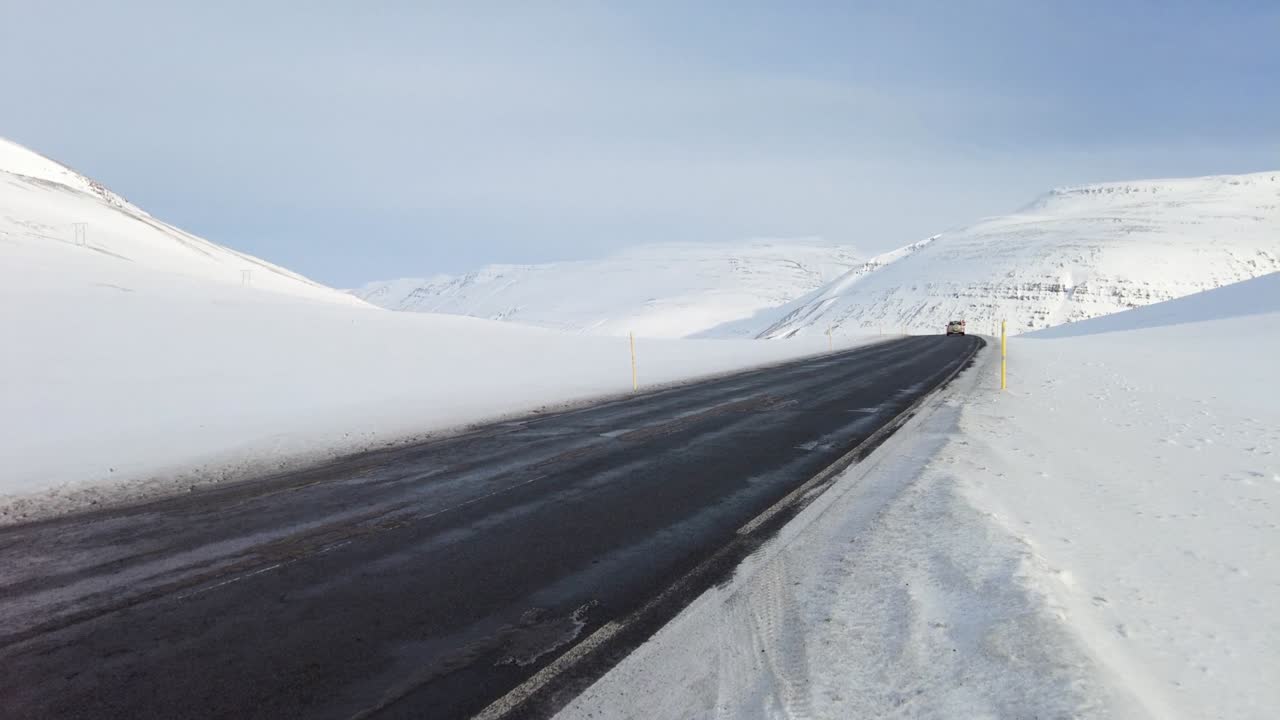아이슬란드 도로에서 차를 운전하는 넓은, 눈 은 산과 해가 지는 시골, 겨울 시간.