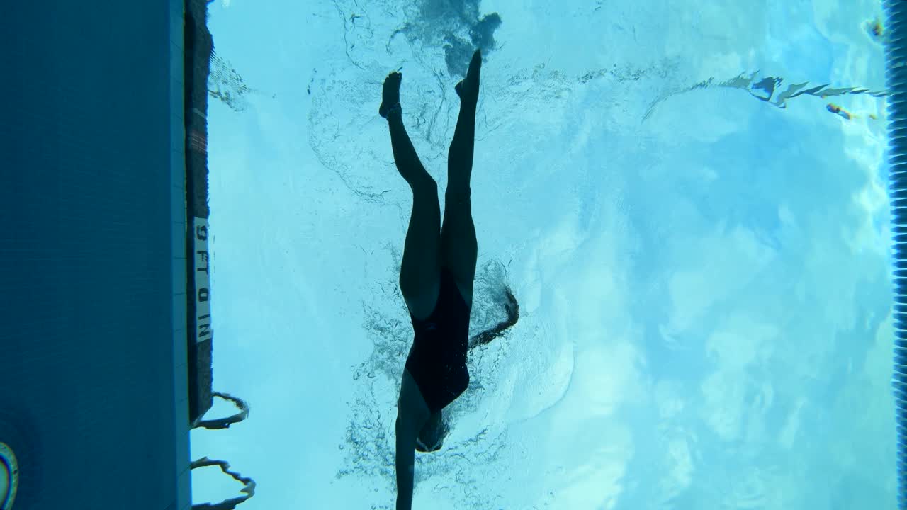 Creative underwater shot of a swimmer swimming in the lanes of a swimming pool
