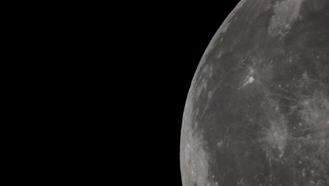 a super telephoto video of the giant full moon passing through the night sky in space taken with a telescope