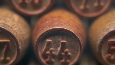 cinematic macro smooth shot of bingo wooden barrels in a row, woody figures, old numbers vintage board game, lucky number 44, slow motion, 4k commercial gimbal movement, dreamy lighting, tilt up