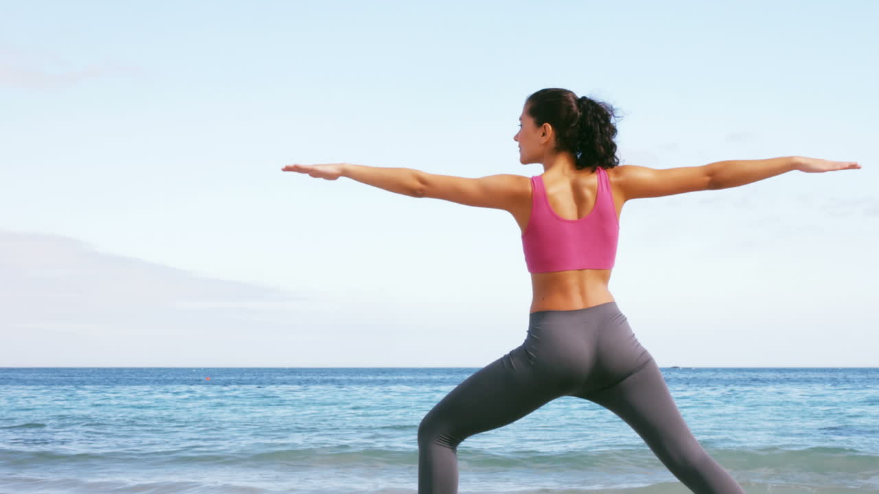 mujer en forma haciendo yoga en la playa