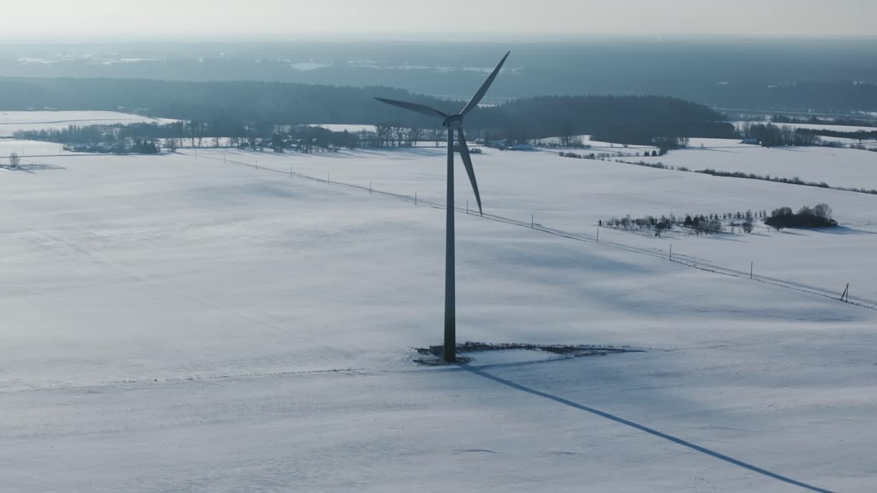 드론은 눈 인 발트 해의 풍경 속에서 외로운 풍력 터빈을 둘러싸고 있습니다.