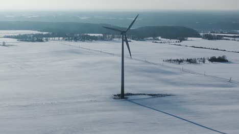 drone encircles a solitary wind turbine amidst the snowy baltic landscape