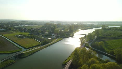 Luftaufnahme-Im-Sonnenuntergang-Auf-Einem-Fluss,-Der-Ein-Vorbeifahrendes-Hausboot-Zeigt