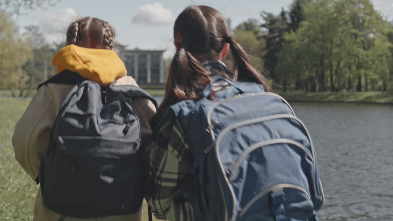 Kids walking near a lake in a park