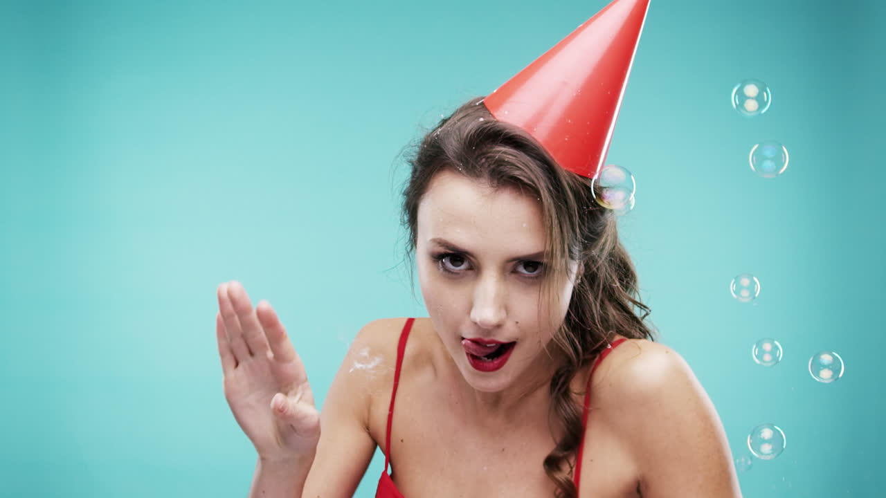 미친 얼굴 섹시한 여자가 거품 샤워에서 춤을 추고 느린 동작 사진 부스 파란색 배경