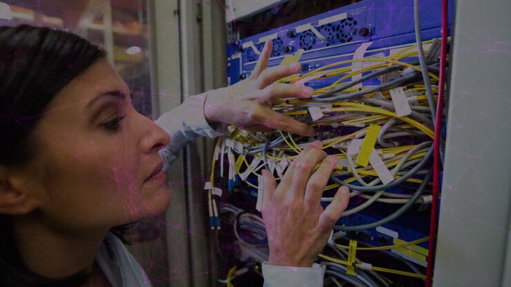 Animation of pink lights over focused biracial women connecting wires in server