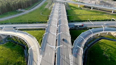 different cars drive along grey highway with turning circle