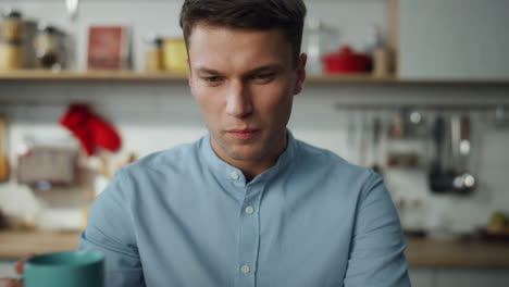 Freelancer-drinking-coffee-working-on-laptop-at-kitchen.-Worker-looking-screen.