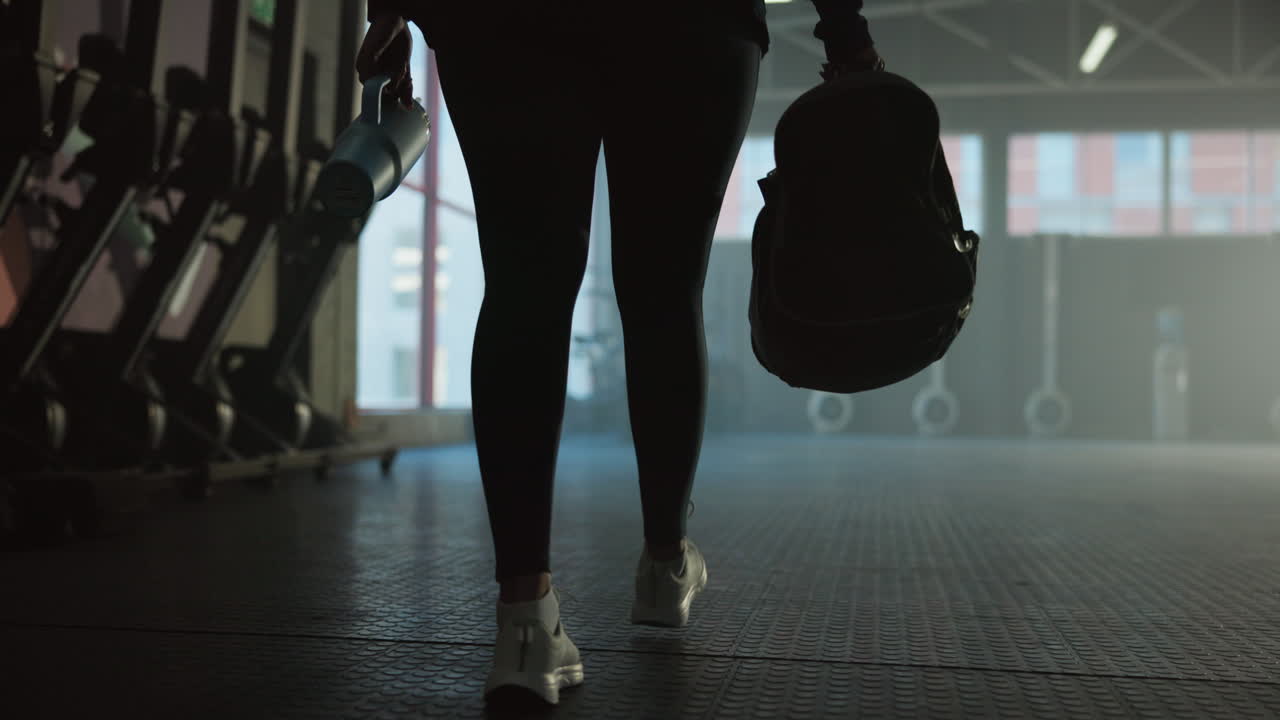 Woman in gym with sports bag and water bottle