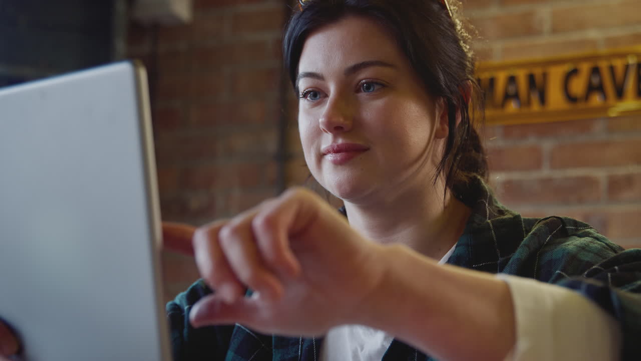 carpintero femenino en un taller de garaje mirando el diseño en una tableta digital