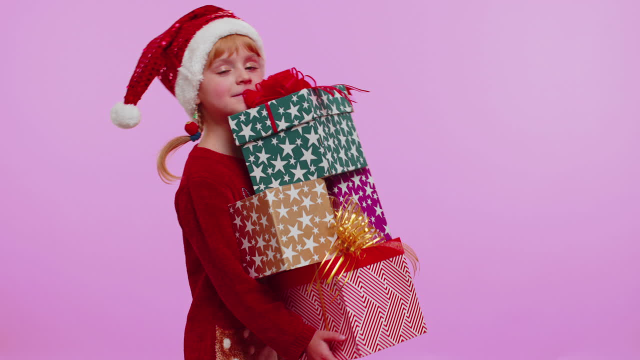 niña con suéter de navidad, sombrero de papá noel, sonriendo, sosteniendo muchas cajas de regalos compras de regalos de año nuevo