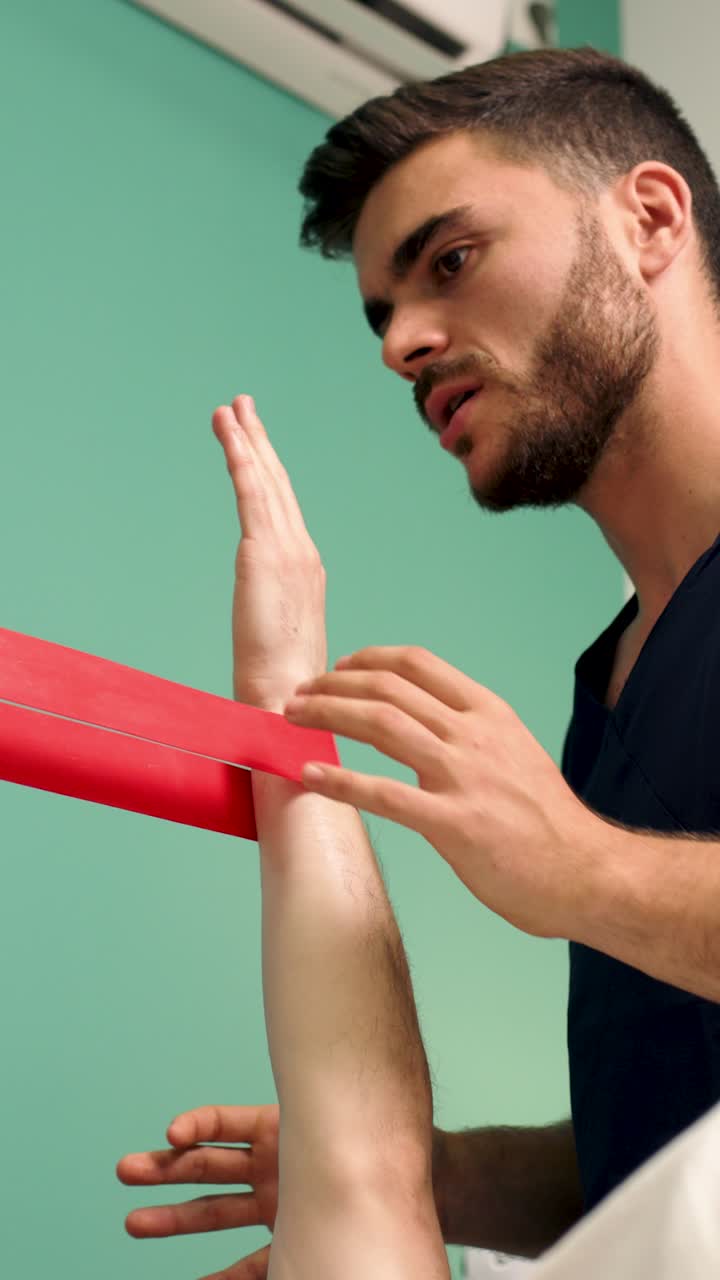 Physiotherapist Guiding Patient's Hand Exercise with Resistance Band