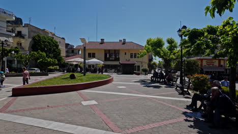 sunny day in a lively town square with people and outdoor cafes