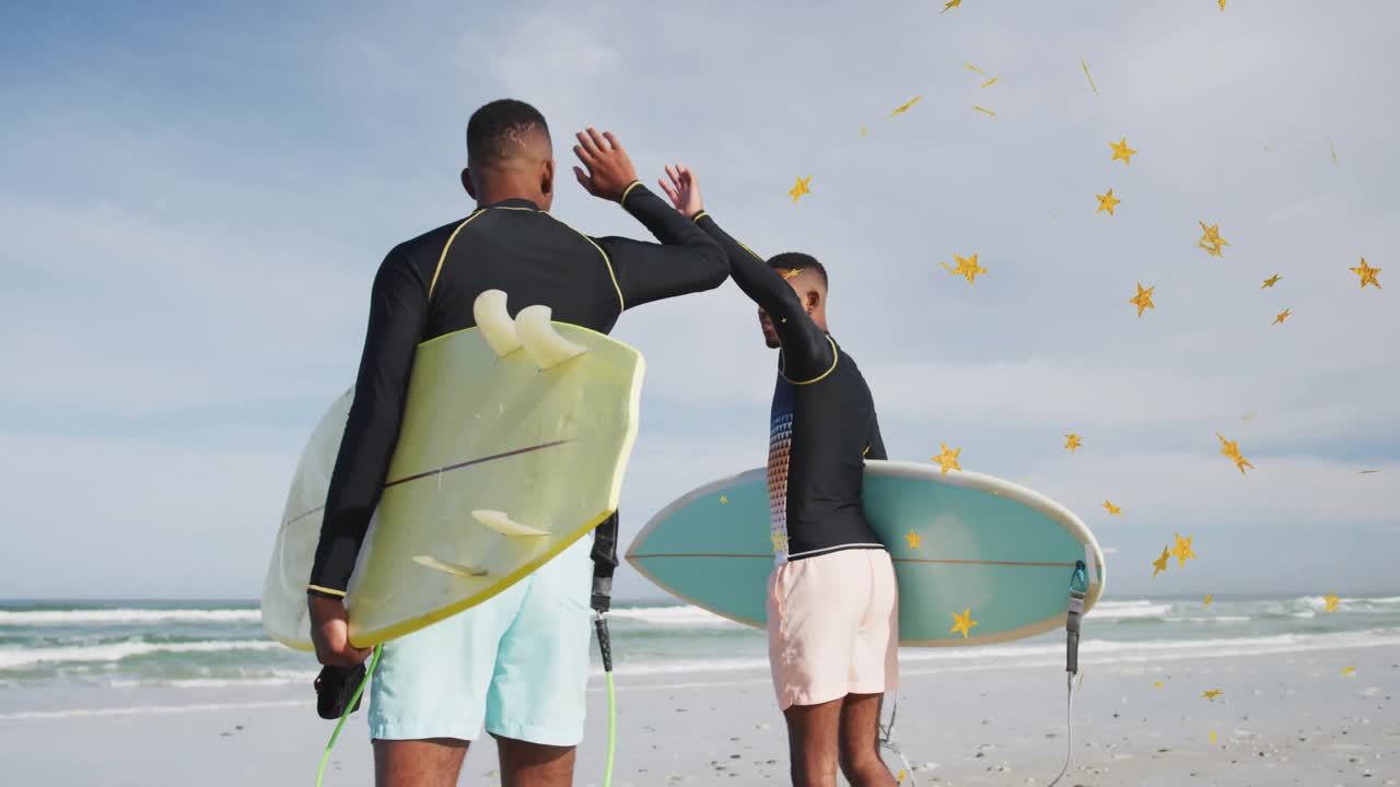 Surf duo exchanging high-five and gripping boards heading toward breaking waves amid golden stars