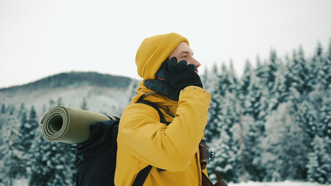 Man in Yellow Coat Talking on Phone in Winter