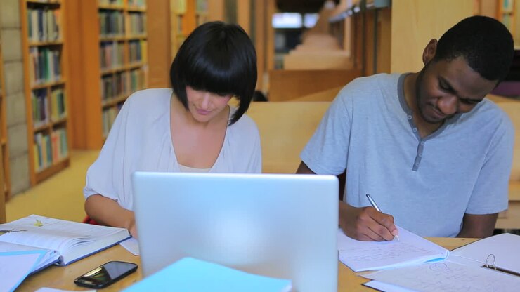 People working on assignments in the library