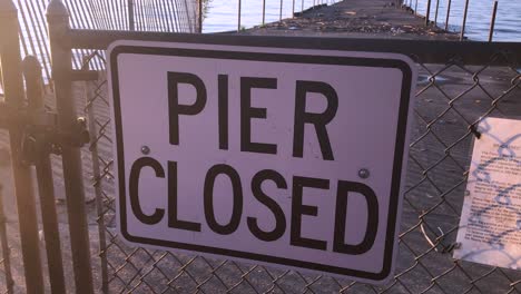 pier closed signs of danger where a beach is not safe and falling into disrepair