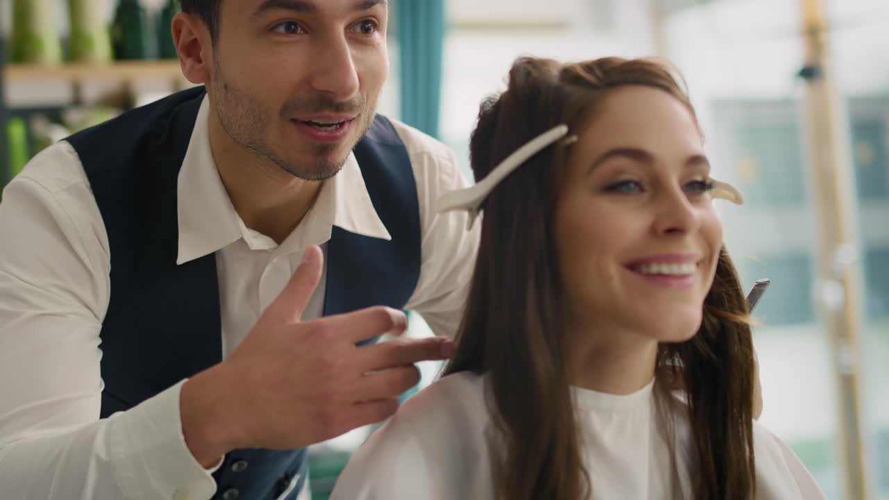 Opname vanuit de hand van een kapper die een vrouw goed advies geeft.