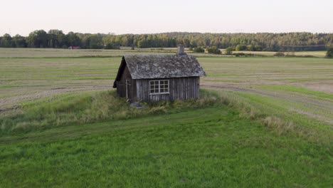 remains of a historical blacksmith shop standing in the agricultural land in dalsland, sweden. aerial drone shot