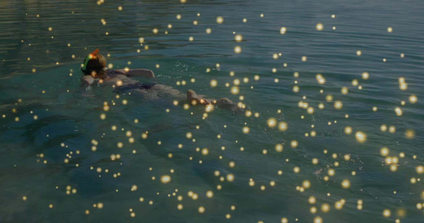 Woman kicking across water, mask and tube creating wake, gold overlay moving around her for travel