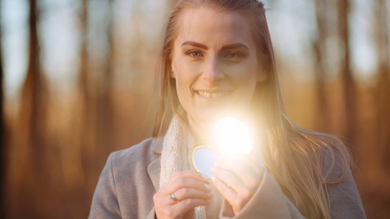 mujer refleja la luz con un pequeño espejo 2