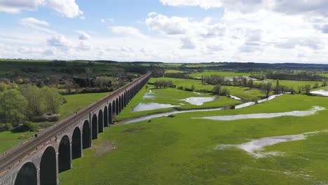 Langsamer-Drohnenflug-Neben-Dem-Welland-Viadukt-In-Northamptonshire,-Auch-Bekannt-Als-Harringworth--Und-Seaton-Viadukt,-An-Einem-Sonnigen-Tag,-Der-Die-Weite-Von-Englands-Längstem-Viadukt-Und-Den-Fluss-Und-Das-Tal-Darunter-Zeigt