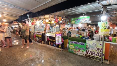 los turistas exploran los vibrantes puestos del mercado por la noche