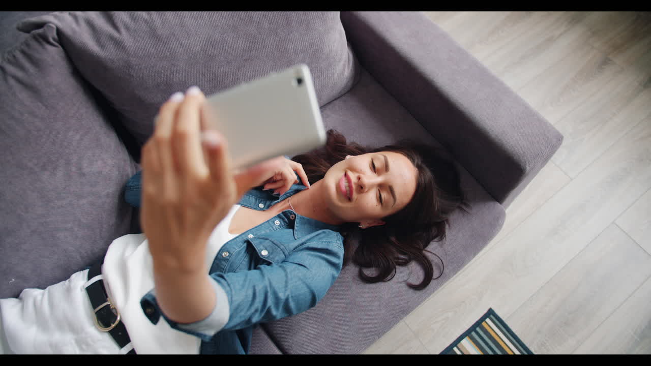 Woman taking a selfie on a couch