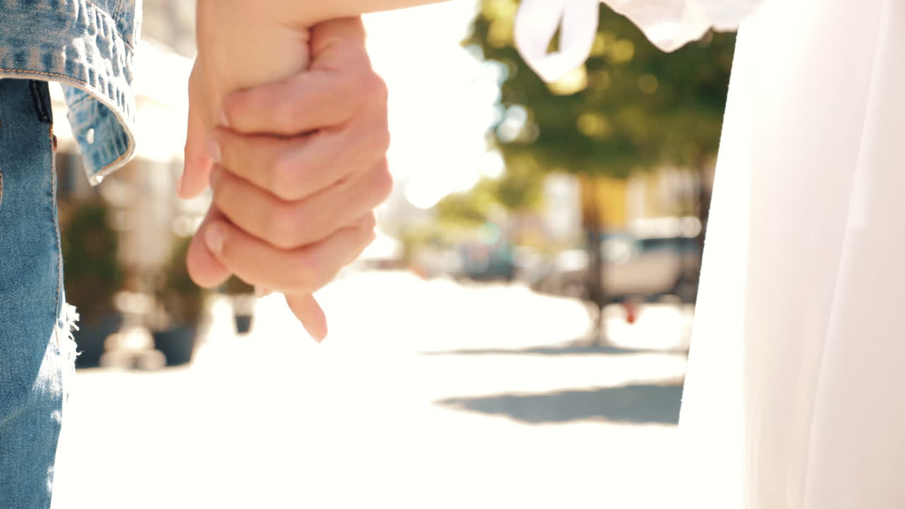 한 부부가 도시 거리에서 손을 잡고 고 있다