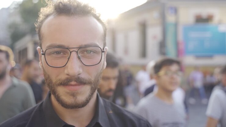 Adolescente che ride e guarda la fotocamera tra la folla