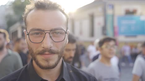 laughing teenager looking at camera among crowd.