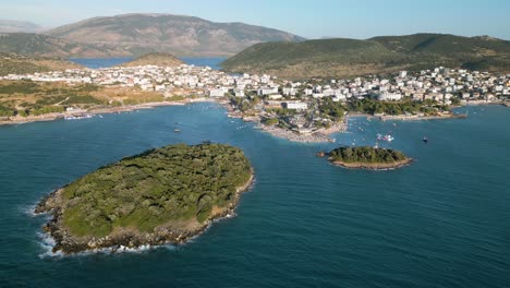 steady drone shot of small waves rooling towards the city of ksamil at the albanian riviera