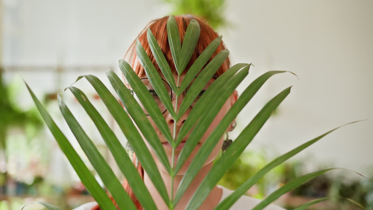 종려나무 잎 뒤에 숨어 있는 여자