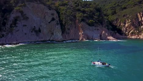 Flying-above-a-yacht,-towards-the-Mediterranean-coastline